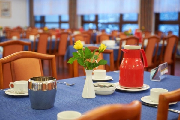 Tisch gedeckt mit Blumenvase und Isolierkanne Tisch gedeckt mit Blumenvase und Isolierkanne