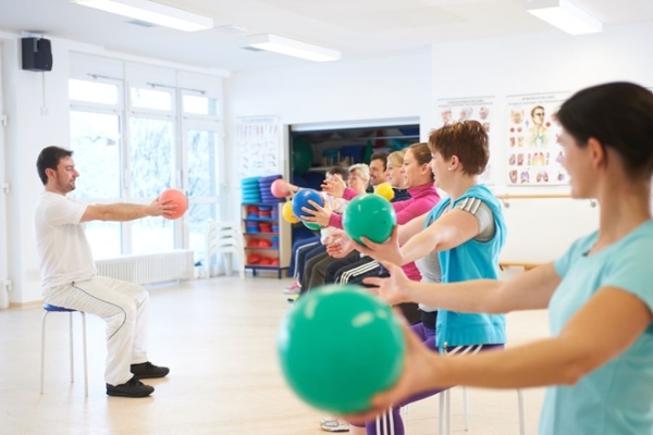 Gruppen auf Hocker sitzen mit Bällen in den Händen Gruppen auf Hocker sitzen mit Bällen in den Händen